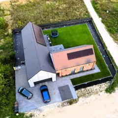 Nowy dom 80m2 pod klucz z panelami słonecznymi, trawnikiem i trampoliną. Koszt budowy domu 80m2 pod klucz jest tu widoczny.