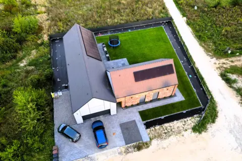 Nowy dom 80m2 pod klucz z panelami słonecznymi, trawnikiem i trampoliną. Koszt budowy domu 80m2 pod klucz jest tu widoczny.