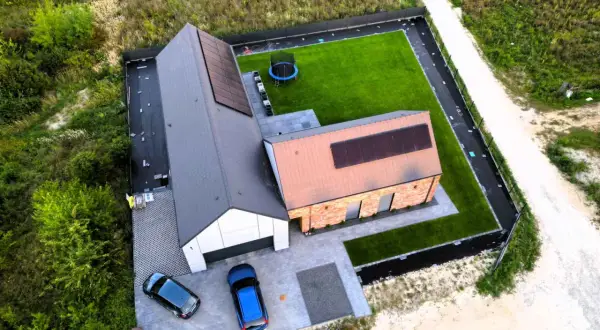 Nowy dom 80m2 pod klucz z panelami słonecznymi, trawnikiem i trampoliną. Koszt budowy domu 80m2 pod klucz jest tu widoczny.