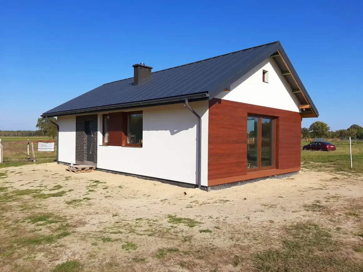 Nowy, nowoczesny dom 100m2 z poddaszem, z drewnianą elewacją i dużymi oknami. Idealny dla rodziny szukającej najtańszy dom.